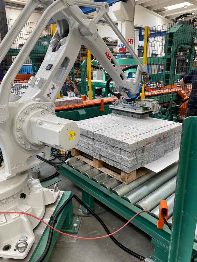 Robot industriale movimenta pallet con blocchi di pietra